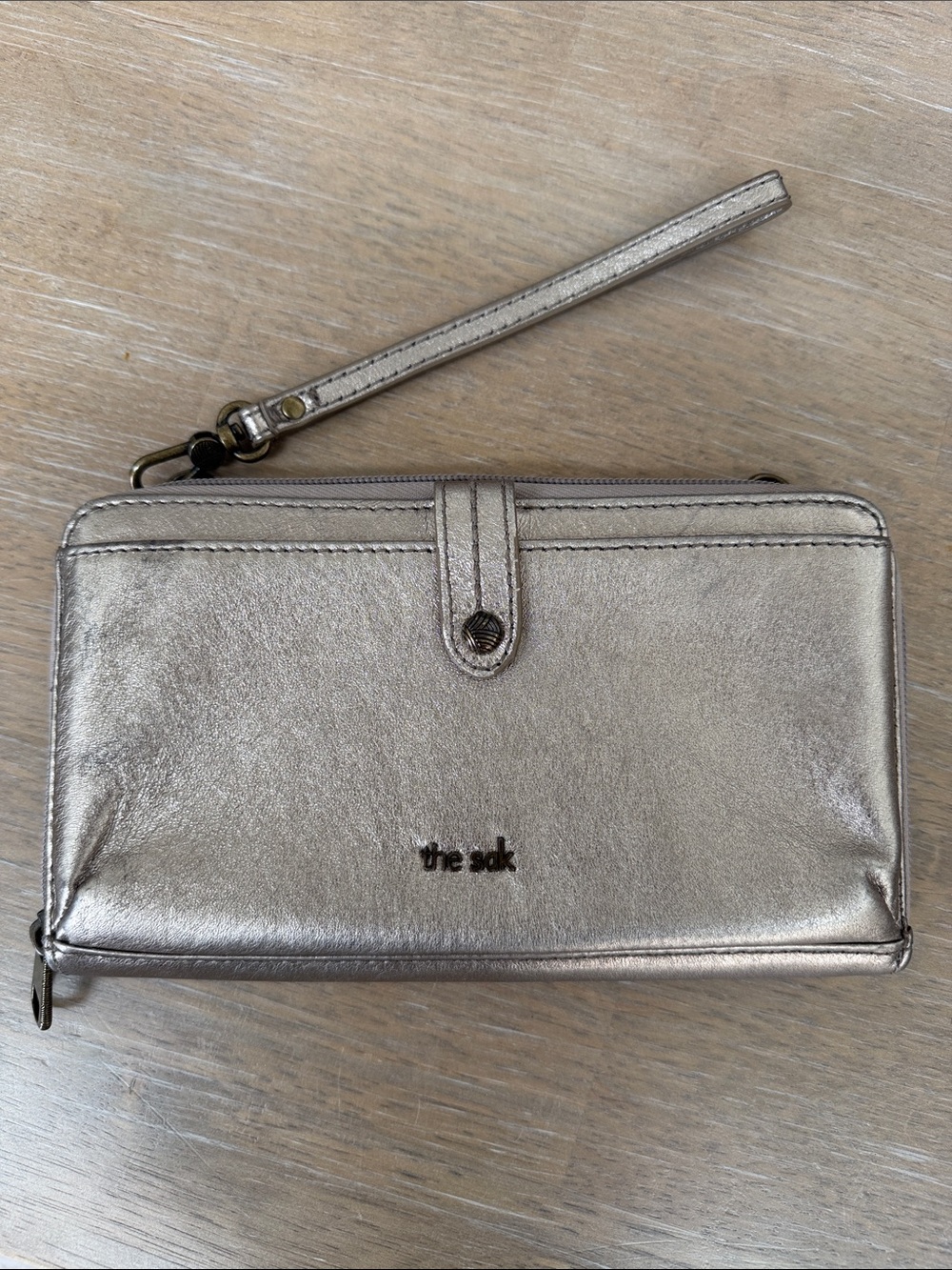 The Sak Iris smartphone wallet in metallic gold leather w/wristlet strap